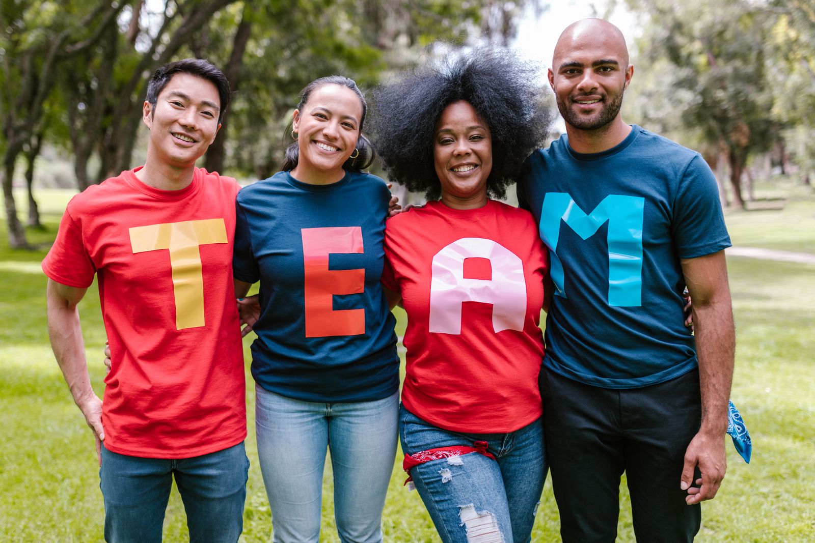 A diverse group of volunteers standing together outdoors, smiling